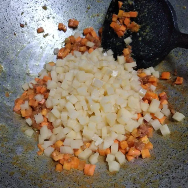 Masukkan kornet, tumis sebentar. Kemudian masukkan wortel dan kentang, aduk rata.