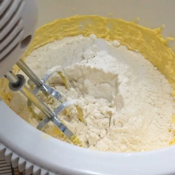 Lalu masukkan tepung terigu, tepung maizena dan susu bubuk, kemudian campurkan seluruh bahan menggunakan mixer.