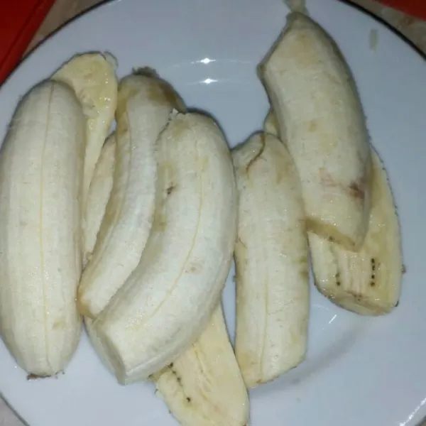 Kupas pisang lalu belah menjadi 2.