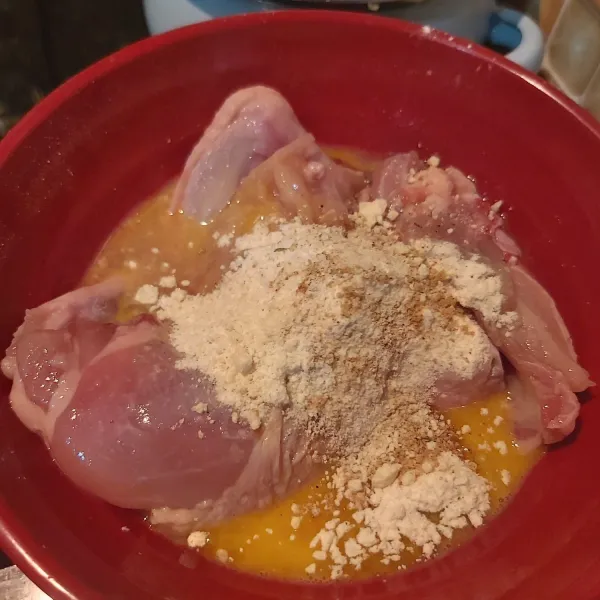 Masukkan ayam dalam wadah. Tambahkan 1 butir telur, 2 sdm tepung terigu, garam, lada dan kaldu jamur secukupnya. Aduk-aduk hingga bumbu merata.