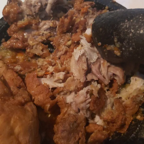 Setelah sambal jadi, geprek ayam hingga hancur dan ratakan sambal pada seluruh permukaan ayam.