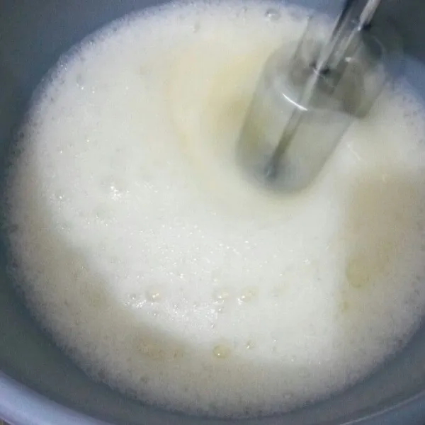 Mixer sampai berbusa lalu masukkan gula pasir, mixer dengan kecepatan tinggi sampai kental.