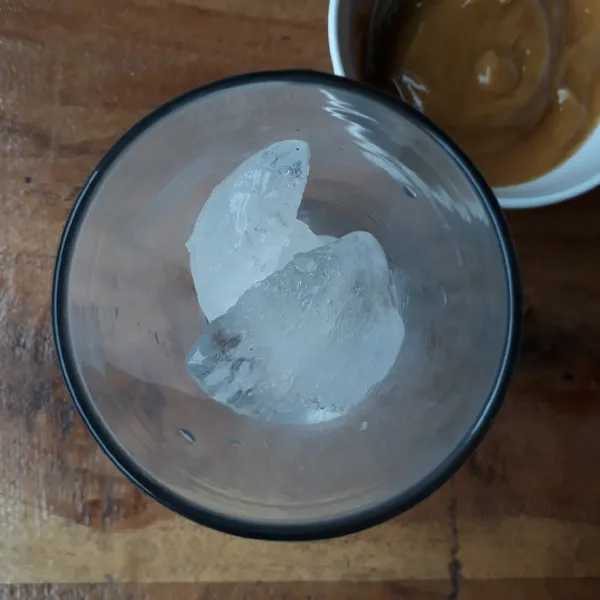 Masukkan es batu ke dalam gelas.