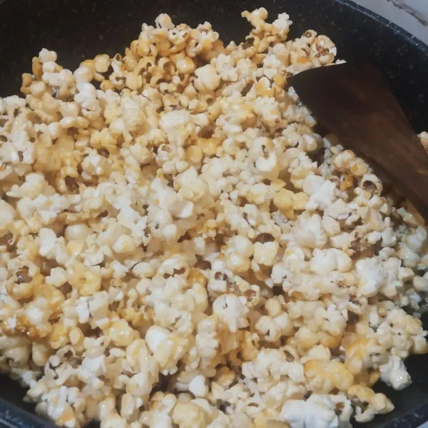 Masukkan popcorn asin ke dalam panci berisi larutan karamel, aduk sampai rata.