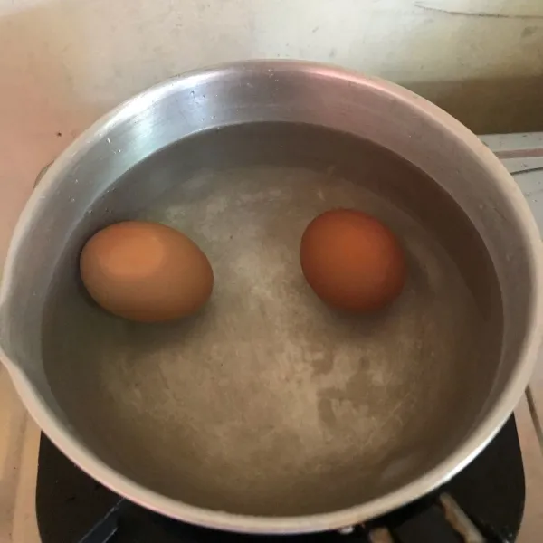 Rebus telur sampai matang sekitar 15 menit lalu kupas kulitnya.