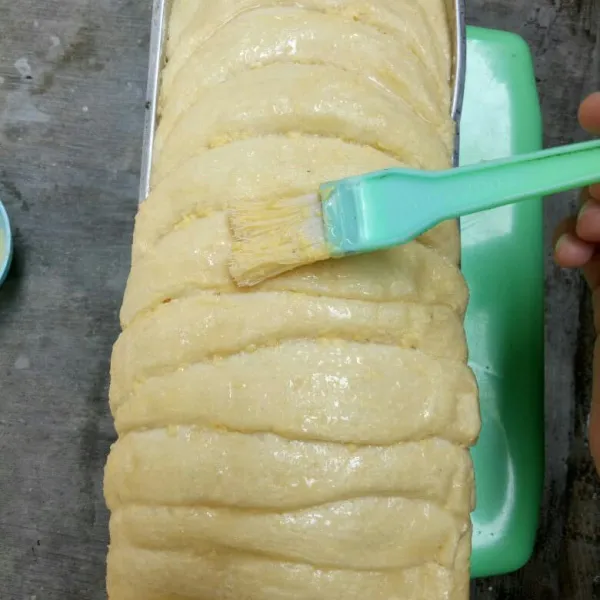 Tata diloyang yang sudah di oles margarin & istirahatkan 45 menit, kemudian oles lagi bagian atasnya dengan bahan olesan tadi.