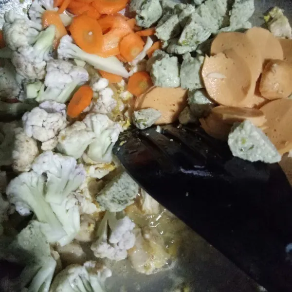 Masukkan wortel, bunga kol, bakso, dan sosis, masak hingga layu.