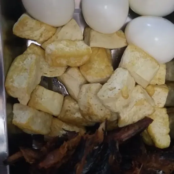 Telur di rebus lalu kupas, tahu goreng setengah matang dan bersihkan pindang tongkol, ambil bagian isinya saja potong-potong lalu digoreng.