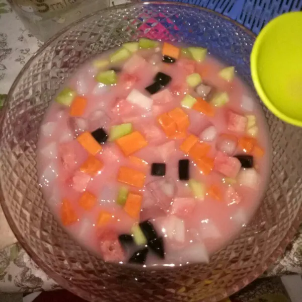 Tambahkan air es, es batu dan sirup coco pandan, aduk sampai tercampur rata