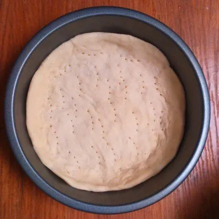 Ambil adonan dough yang sudah mengembang. Sesuaikan ukuran loyang yang akan dipakai. Untuk diameter 15 cm bagi adonan menjadi 3 kemudian tipiskan adonan dan ratakan dalam loyang. Kemudian tusuk dengan garpu agar matang merata.