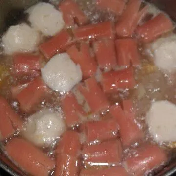 Lalu masukkan bawang putih yang sudah ditumis, udang, sosis dan bakso. Bumbui dengan garam, gula, merica bubuk dan kaldu bubuk aduk rata