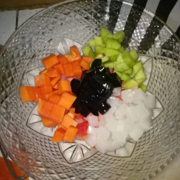 Siapkan wadah besar, cuci bersih dan potong dadu buah semangka, melon, pepaya, cincau dan nata de coco