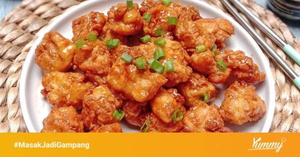 Piring saji dengan ayam crispy dan saus madu wijen di tengah