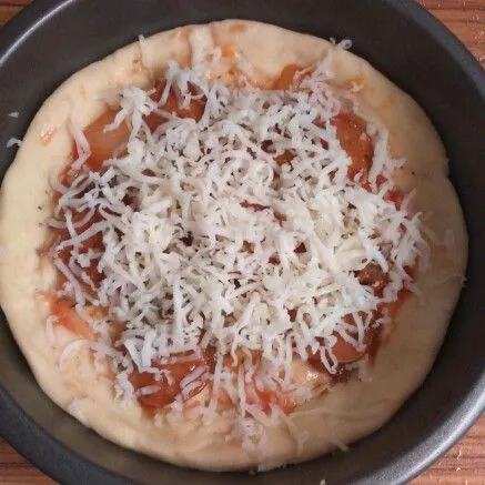 Olesi dengan 1 sdm saos tomat, tambahkan topping, taburi oregano dan parutan keju mozarella. Panggang pizza dengan api sedang (suhu 160 C) selama 15 menit.