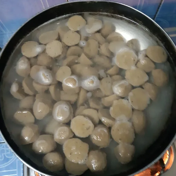 Iris bakso, belah menjadi 2, rebus hingga matang dan mengembang, buang air rebusan, cuci bersih bakso, sisihkan.
