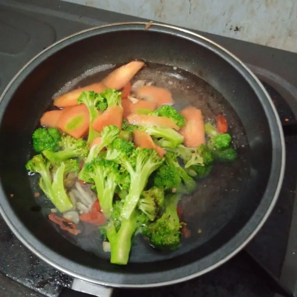 Kemudian masukkan brokoli dan wortel tambah sedikit air masak sampai empuk