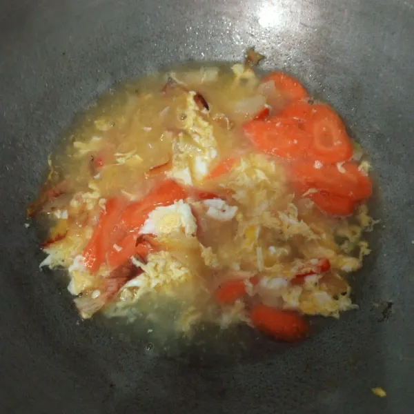 Masukkan telur, orak arik. kemudian masukkan wortel tambah sedikit air masak sampai air menyusut