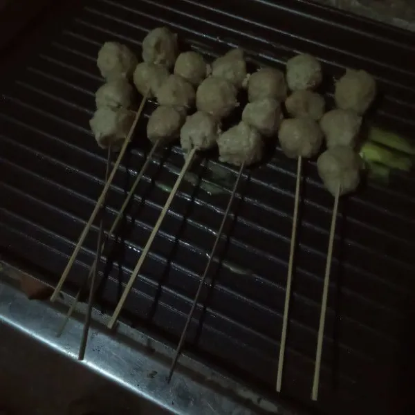 Siapkan tusuk sate, lalu tusuk bakso lalu masukan ke atas pan lakukan sampai bakso habis.