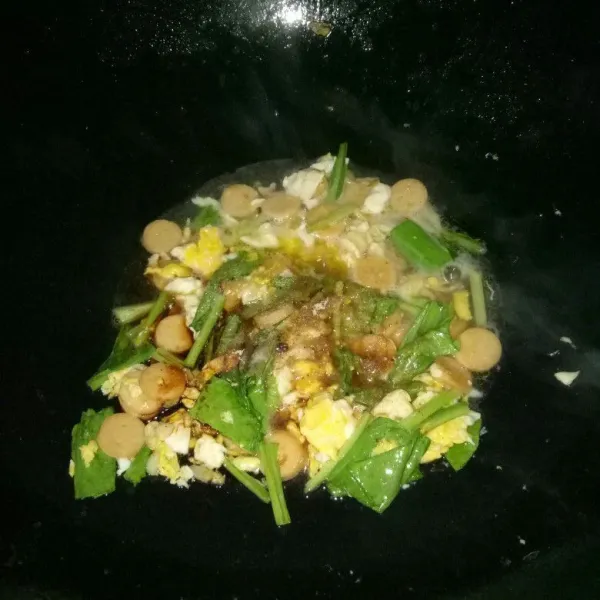 Masukan sawi, sosis, gula, garam, kecap manis, kaldu bubuk dan air. Masak sampai air surut dan sawi matang