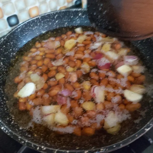 Goreng kacang tanah, bawang putih dan bawang merah hingga matang atau sampai kacang tanah berwarna coklat tua.