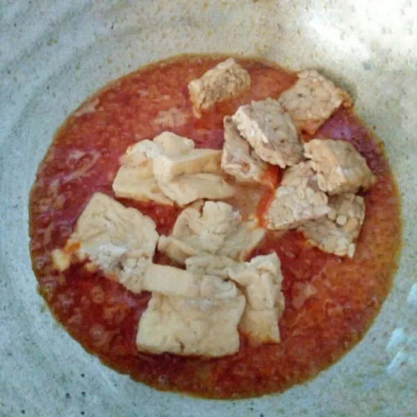 Tuangi air. Masukkan tahu tempe. Masak hingga mendidih. Bumbui dengan garam, gula dan kaldu bubuk.