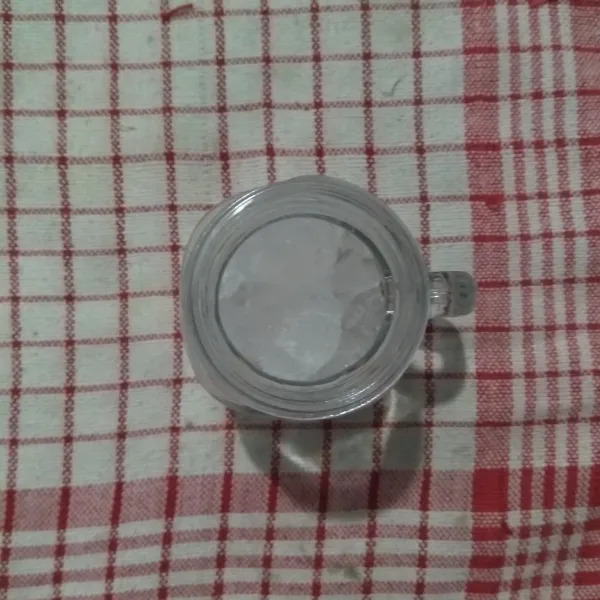 Masukkan es batu ke dalam gelas.