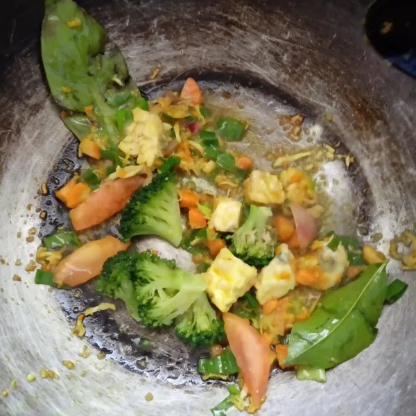 Masukkan brokoli, wortel, tempe, daun salam, daun bawang, aduk rata.