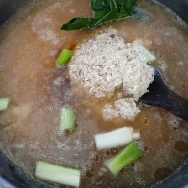 Setelah ayam matang, angkat dan tiriskan ayam. Selanjutnya cuci beras dan masak menggunakan air kaldu saat merebus ayam. Takarannya seperti cara biasa untuk memasak nasi. Tambahkan saus tiram, kecap asin, potongan daun bawang dan daun pandan.