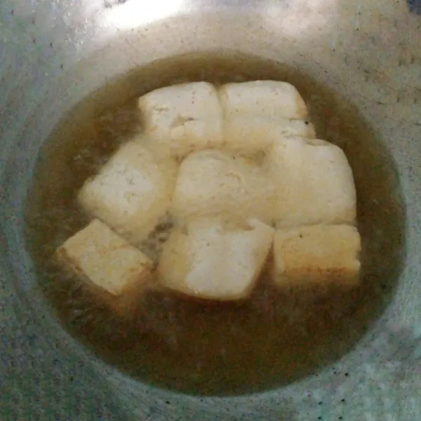 Tahu putih dicuci bersih. Kemudian potong-potong. Goreng setengah kering. Tiriskan dari minyaknya.