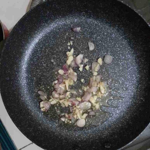 Panaskan minyak dalam teflon, tumis bawang merah iris dan bawang putih cincangnya sampai harum dan berubah warna.