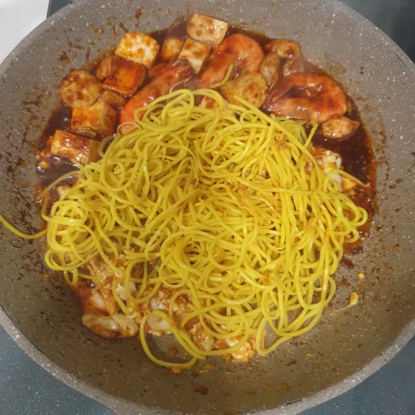 Masukan mie kuning, aduk rata, dan masak sebentar.