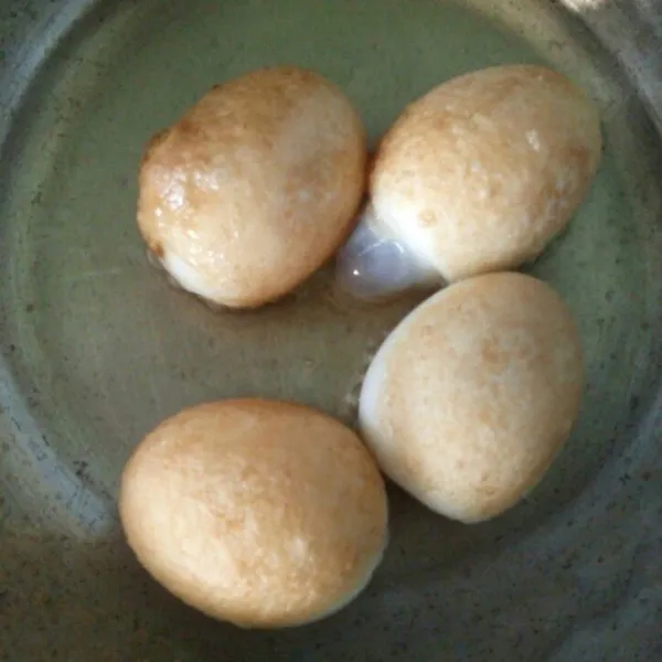 Kupas telur rebus, kemudian goreng hingga berkulit. Tiriskan dari minyaknya.