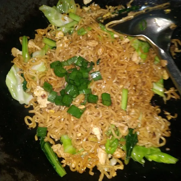 Tambahkan daun bawang. Mie goreng spesial ayam dan telur siap disajikan.