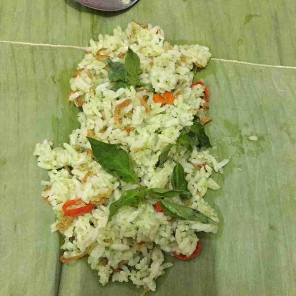 Ambil daun pisang, taruh nasi tambahkan daun kemangi, bungkus nasi dengan rapat dan padat, sematkan dengan lidi.