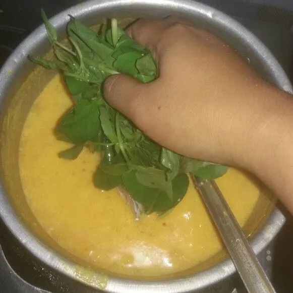 Lalu masukkan juga kemangi. Bubuhkan garam, gula dan kaldu bubuk. Masak hingga ikan matang.