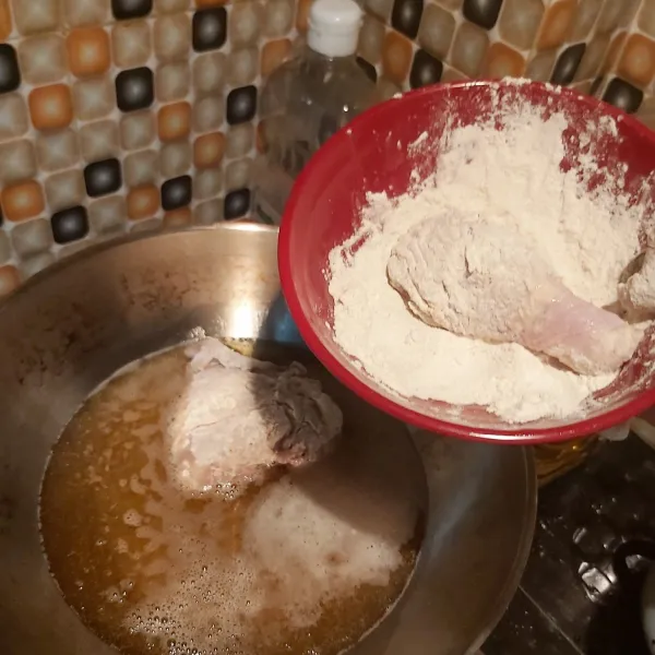 Siapkan 5 sdm tepung terigu dalam wadah. Kemudian goreng ayam dalam minyak panas dan api kecil dengan terlebih dahulu dibubuhkan pada tepung terigu.