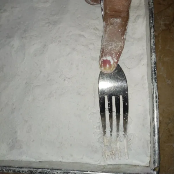 Kerat-kerat tepung yang sudah padat dengan garpu hingga mendapat tekstur seperti gumpalan.