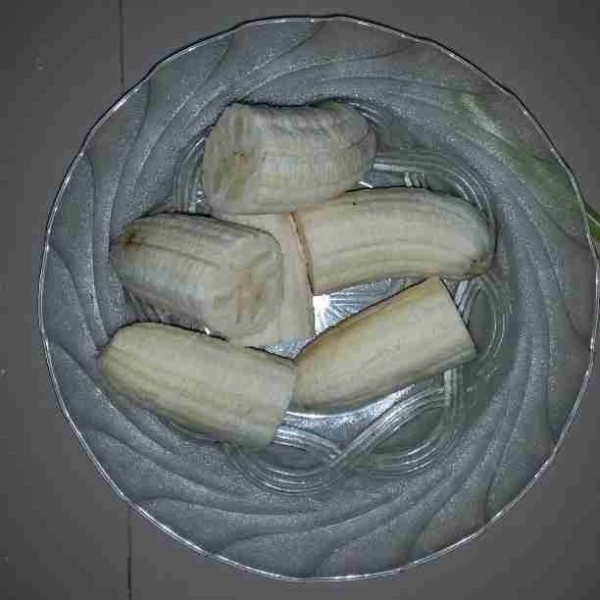 Kupas pisang kemudian belah menjadi 2 bagian.