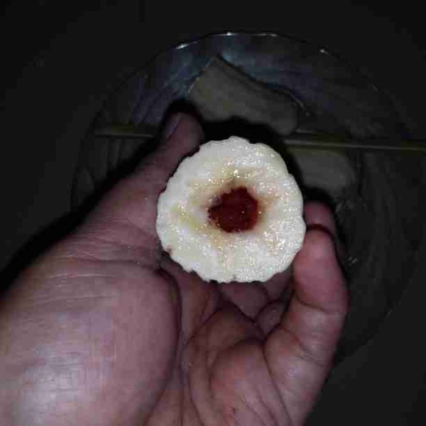 Masukan selai strawbery ke dalam piping bag/plastik segitiga. Gunting ujung piping bag kemudian semprotkan ke dalam lubang pisang.