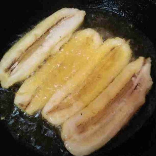 Kupas pisang belah menjadi 2 bagian lalu goreng sampai matang.