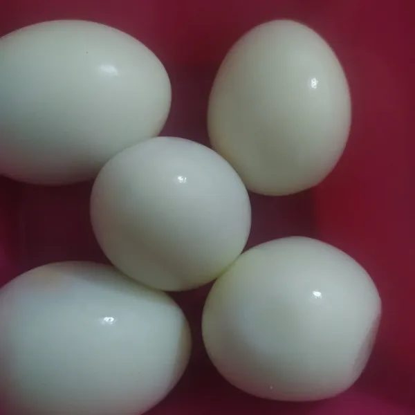 Rebus telur yang sudah bersih, ketika di angkat masukkan ke dalam air es lalu kupas. Air es membuat telur yang dikupas lebih gampang dan mulus.