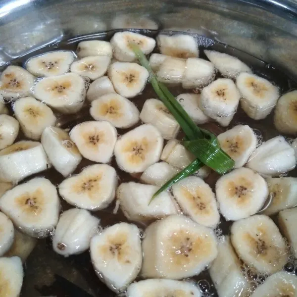 Masukkan potongan pisang masak hingga pisang matang, matikan api tunggu hingga uap panasnya hilang.
