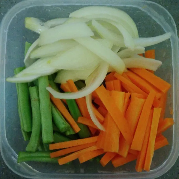 Sambil menunggu cumi dimarinasi, siapkan sayuran. Cuci bersih sayuran, potong memanjang wortel dan bawang bombay. Potong menjadi 4 bagian buncis.