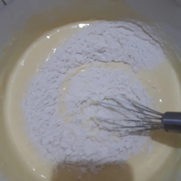 Masukkan tepung terigu dan vanilla essence secukupnya. Aduk-aduk lagi hingga merata.