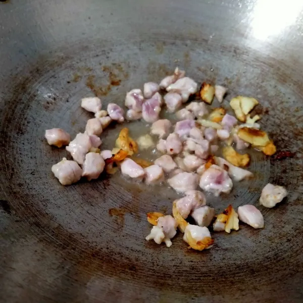 Tumis bawang putih hingga harum. Kemudian masukkan daging ayam. Masak hingga daging berubah warna. Lalu tambahkan secukupnya air. Masak sekitar 3 menit.