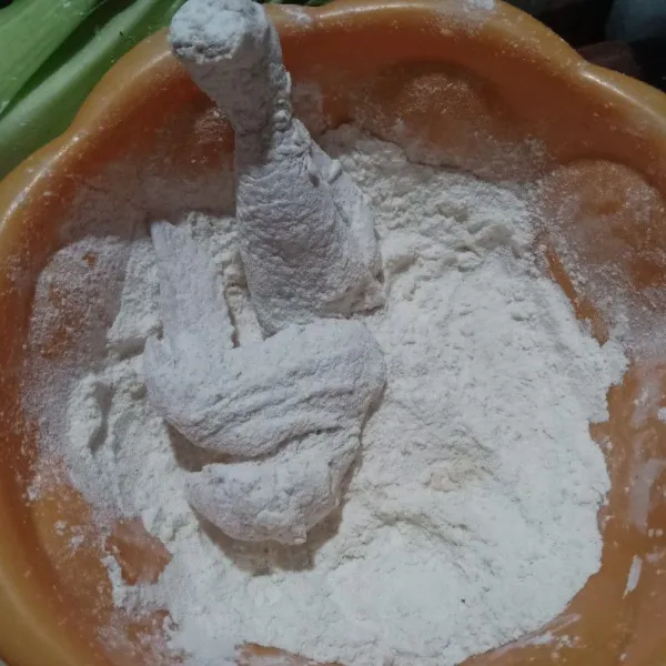Setelah dimarinasi, baluri dengan tepung terigu, kemudian dilanjutkan dengan tepung bumbu ayam goreng. Tebaskan sebelum digoreng.