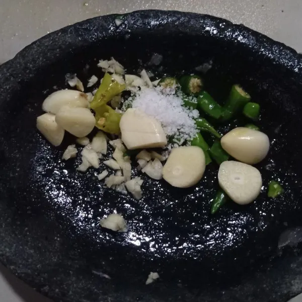 Kemudian siapkan bawang putih, cabe rawit hijau, dan garam. Haluskan, kemudian masukkan ke dalam air gula yang tadi sudah disaring