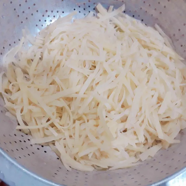 kupas kentang. potong seperti korek api tipis. taburi garam. diamkan 10 menit. cuci bersih & tiriskan