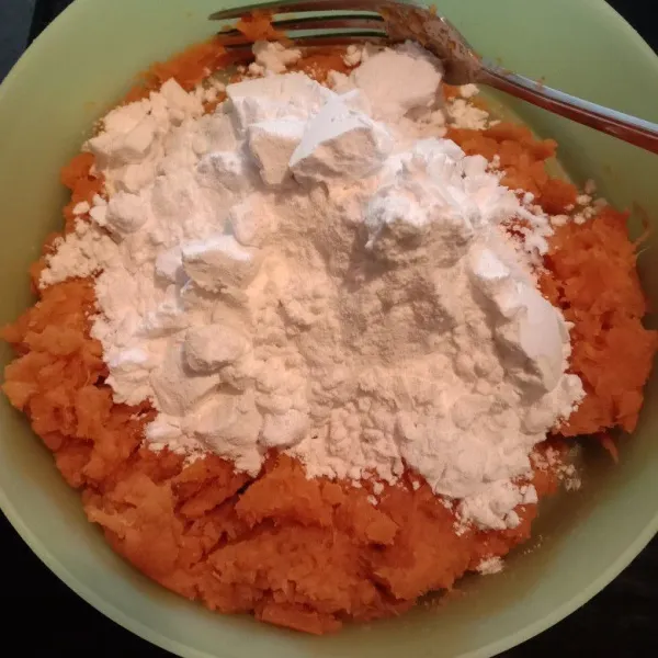 Setelah ubi benar-benar halus dan lembut tambahkan gula pasir dan tepung tapioka, aduk hingga rata dan menjadi adonan yang kalis serta mudah dibentuk.