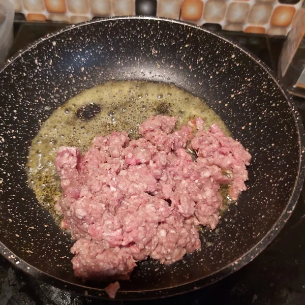Membuat beef bolognese.  Panaskan 2 sdm mentega. Tumis daging cincang hingga berubah warna.